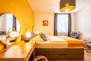 因斯布鲁克Apartment "Deluxe" Innsbruck - Mutters的一间卧室配有一张床、一张书桌和一面镜子