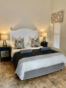 博福特西The Merino Guest House - B&B的一间卧室配有一张大床和枕头