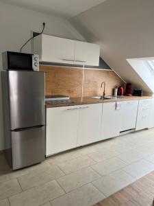 巴特温普芬New Age Boardinghaus Bad Wimpfen的厨房配有白色橱柜和不锈钢冰箱