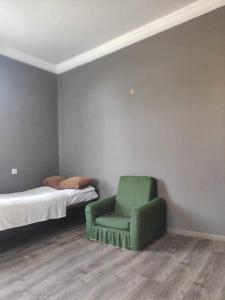 阿哈尔齐赫Katly的一间卧室配有绿色椅子和一张床