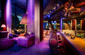 柏林HOTEL BERLIN KÖPENICK by Leonardo Hotels的一间酒吧,配有紫色椅子和吧台