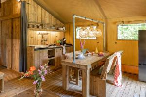 费尔普Buitenplaats Beekhuizen的帐篷内的厨房配有木桌