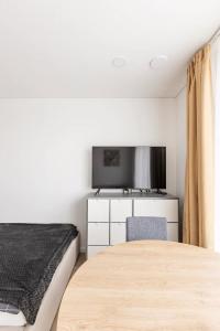 维尔纽斯Ozo eco apartments的一间卧室配有一张床和一台平面电视