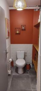 圣保罗德费努耶Maison de village avec une pièce de vie lumineuse的浴室设有白色卫生间,位于橙色的墙壁上