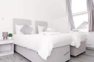 BickleyCity Village的白色卧室配有一张带白色床单和枕头的大床
