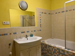 德辛朋克御碑亭位酒店的一间带水槽、浴缸和镜子的浴室