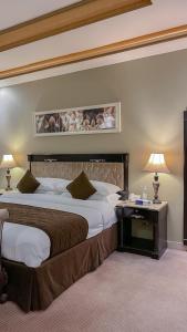 奈季兰Levant Hotel的酒店客房设有两张床和一张带台灯的桌子。
