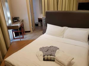 新加坡Amrise Hotel Kitchener的卧室配有白色的床和书桌