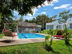 梅尔加Finca Summerland ecohotel的一座带游泳池和秋千的别墅