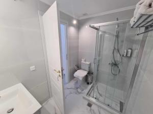 斯巴达NN Rooms and Suites near Athens Airport的带淋浴和卫生间的白色浴室