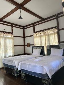卡里蒙贾瓦Dewa Daru Resort的卧室设有两张单人床和木制天花板。