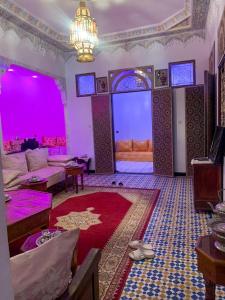 梅克内斯Riad Sibari的一间拥有紫色照明的客厅和一间带沙发的房间