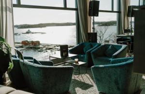 斯特伦斯塔德Scandic Laholmen的客厅设有蓝色椅子和大窗户