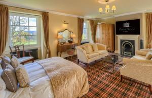 布雷肯彼特斯通苑乡间别墅餐厅及Spa酒店的一间卧室设有一张床,客厅设有壁炉。