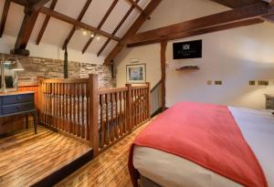 布雷肯彼特斯通苑乡间别墅餐厅及Spa酒店的一间卧室配有一张床,铺有木地板