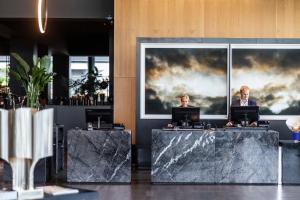 哥本哈根哥本哈根机场克拉里昂酒店的大堂设有2张桌子,上面摆放着笔记本电脑