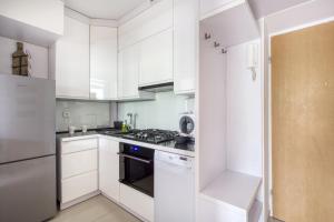 华沙Labo Apartment Ogrodowa的白色的厨房配有炉灶和冰箱。