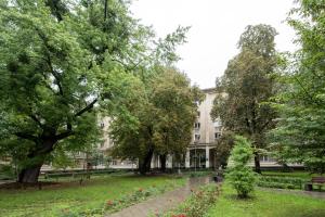 华沙Labo Apartment Ogrodowa的一座树木和鲜花的建筑前的公园