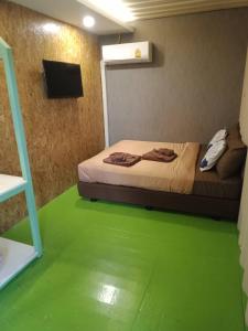董里Kipbox Hotel Trang的一间卧室设有一张绿地床