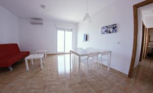 滨海罗克塔斯Be Free Laguna Playa的客厅配有桌椅和红色沙发