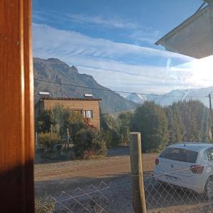 圣卡洛斯-德巴里洛切Tiny house Bariloche的停在有栅栏的房子外的汽车
