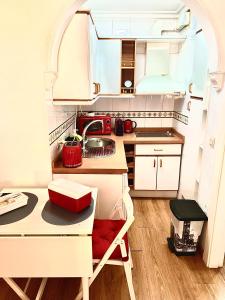 马拉加Ana's Apartment parking gratuito的一个带桌子和水槽的小厨房