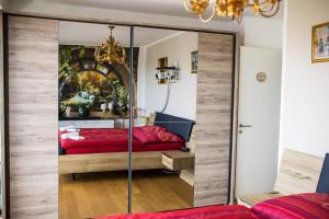 萨勒河畔哈雷Zentrum und Whirlpool 107m2 Händel-Suite by Meis - Perfekt für längere Aufenthalte!的卧室配有带镜子的衣柜和红色的床