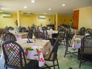福塔莱萨Marbello Ariau Hotel的用餐室配有桌椅和鲜花