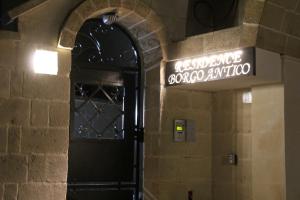 迪索博尔戈安蒂科公寓式酒店的通往建筑物的门,上面有读交换库的字幕