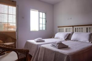 拉拉古纳Cozy Apartment in La Laguna的一间卧室配有两张带毛巾的床