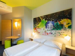 鲁尔河畔米尔海姆鲁尔河畔米尔海姆住宿加早餐酒店的卧室配有一张床,墙上挂有绘画作品