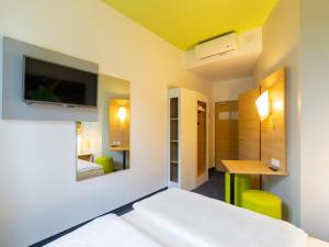 鲁尔河畔米尔海姆鲁尔河畔米尔海姆住宿加早餐酒店的卧室配有一张床,墙上配有电视。