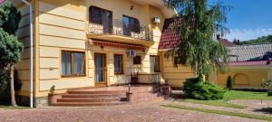 别列戈沃VILLA VERA的黄色的房屋设有楼梯和阳台
