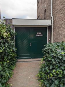 鹿特丹B&B Berglust的绿色车库门,上面有标志