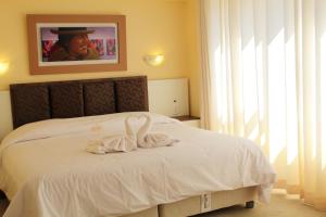 普诺Kaaro Hotel El Buho的一间卧室配有一张床,上面有两条毛巾