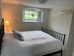 斯塔德Lilla Stenhuset的卧室配有白色的床和窗户
