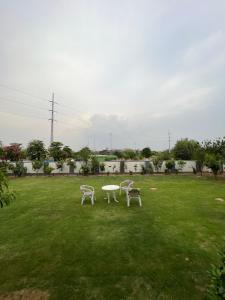 伊斯兰堡DHA 2 Islamabad的草地上的两把椅子和一张桌子