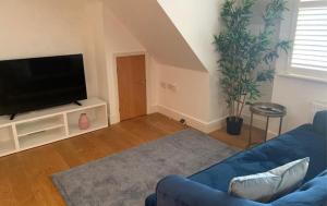 阿德尔斯通Addlestone - Large Stunning 2 bed room Apartment的客厅配有蓝色的沙发和平面电视。