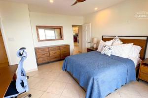 辛普森湾Villa Sea Forever @ Pelican Key - Paradise Awaits!的一间卧室配有一张带蓝色毯子的床和梳妆台
