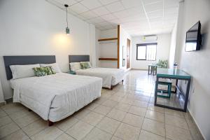 切图马尔Hotel & Suites Arges - Centro Chetumal的一间卧室配有两张床和一张桌子