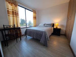 昆卡Casa en Cuenca的一间卧室设有一张床和一个大窗户
