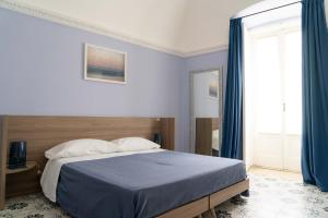 巴列塔Le tre rondini的一间卧室配有一张带蓝色床单的床和一扇窗户。