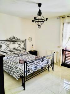 贝尔韦代雷Belvedere House Holiday Siracusa Ortigia的卧室配有一张带吊灯的黑白床。