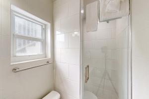 马拉松Citrus Room的带淋浴和卫生间的浴室以及窗户。