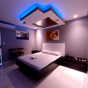 戈亚尼亚GRAN MOTEL GYN的一间卧室配有一张蓝色灯光的床