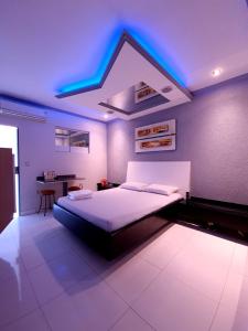 戈亚尼亚GRAN MOTEL GYN的一间卧室配有一张蓝色灯光的床