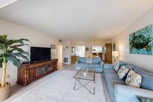 霍姆斯海滩West Bay Point 12的客厅配有蓝色的沙发和平面电视。