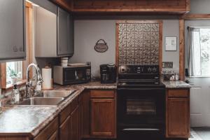 RockbridgePatriot Cottage at American Heartland Cabins的厨房配有黑炉和水槽。