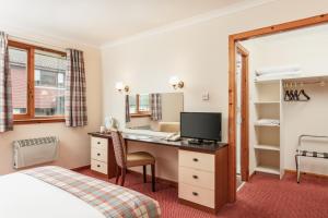 牛顿莫尔汉兰达酒店“定制型酒店”的酒店客房配有书桌和床。