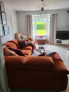 RaphoeTullyvinney Lodge的客厅配有2张棕色沙发和电视